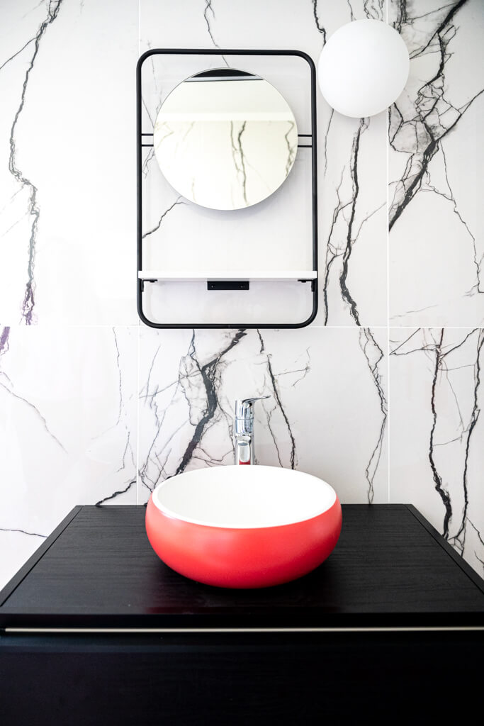 lavabo rouge de salle de bain et marbre au mur